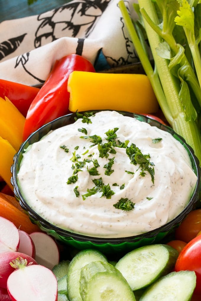 Homemade Ranch Dip Recipe | Homemade Ranch Powder | Homemade Ranch Dressing | Best Ranch Dip #ranch #dip #appetizer #snack #uzhal A bowl of dip topped with chopped parsley and surrounded by vegetables.