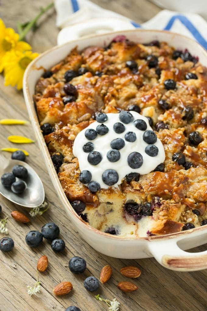 Blueberry Bread Pudding Recipe | Blueberry Bread Pudding | Easy Bread Pudding #blueberry #breadpudding #dessert #uzhal A pan of blueberry bread pudding topped with streusel and caramel sauce.