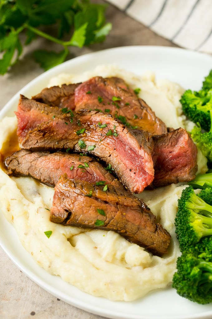Beef slices served with mashed potatoes and broccoli.