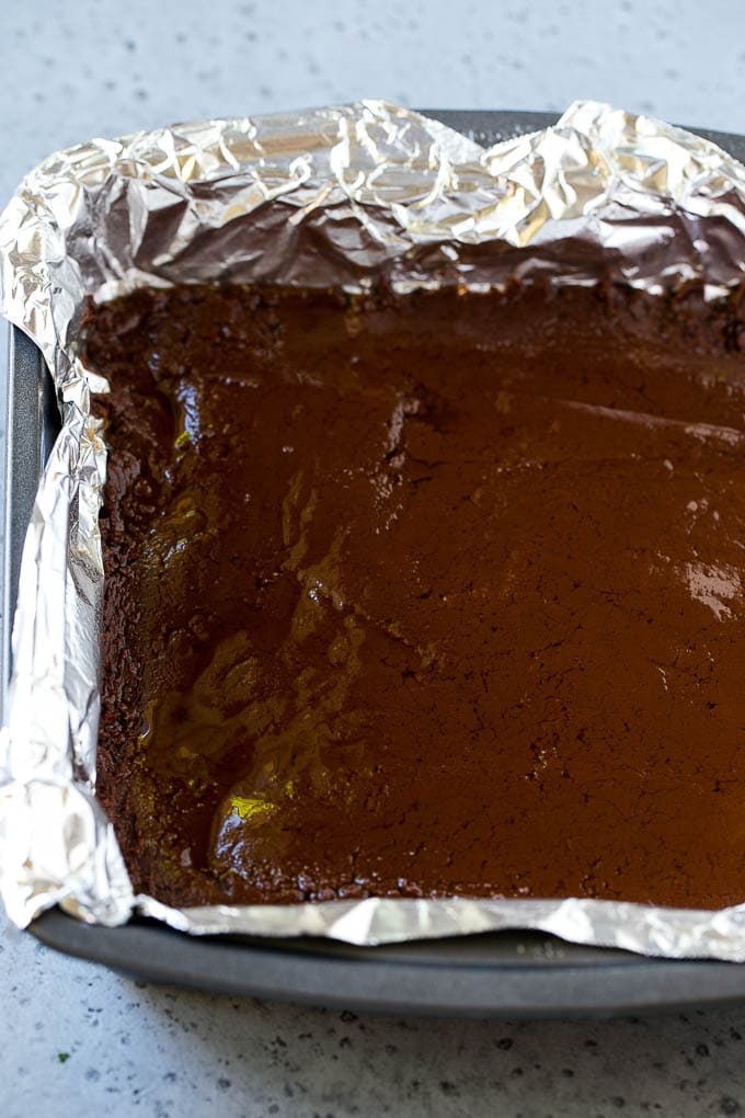 Chocolate Peanut Butter Fudge Recipe | Peanut Butter Cup Fudge | Easy Fudge Recipe #chocolate #peanutbutter #fudge #baking #dessert #uzhal A layer of chocolate fudge in a pan.