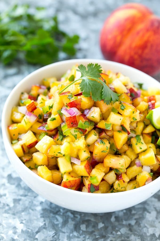 Peach Salsa | Fruit Salsa #peaches #salsa #dip #appetizer #uzhal Peach salsa in a bowl made with red onion, jalapeno and cilantro.