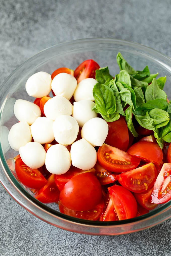 Caprese Salad Recipe | Tomato Salad #salad #tomato #mozzarella #cheese #basil #caprese #summer #uzhal Tomatoes, mozzarella and basil in a bowl.