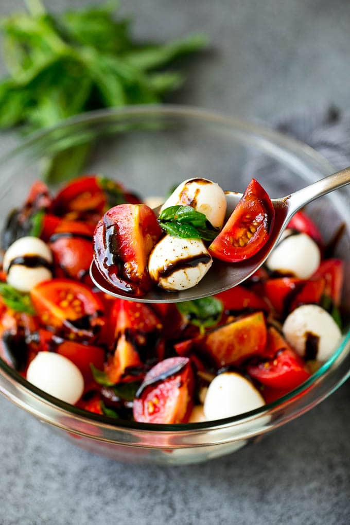 Caprese Salad Recipe | Tomato Salad #salad #tomato #mozzarella #cheese #basil #caprese #summer #uzhal A serving spoon of caprese salad with tomato, mozzarella and basil.