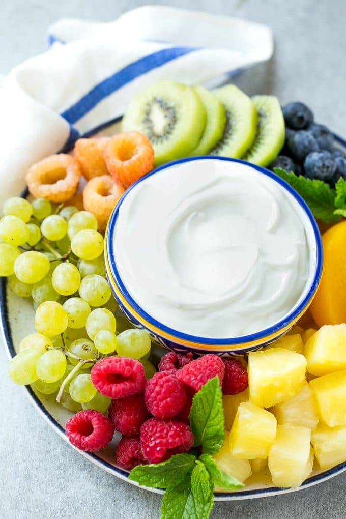 Cream Cheese Fruit Dip | Fruit Recipe | Fruit Dip #fruit #dip #creamcheese #snack #dessert #uzhal A bowl of cream cheese fruit dip surrounded by colorful fruit.