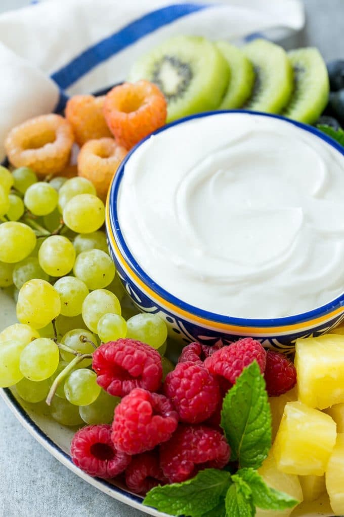 Cream Cheese Fruit Dip | Fruit Recipe | Fruit Dip #fruit #dip #creamcheese #snack #dessert #uzhal A bowl of cream cheese fruit dip surrounded by grapes, raspberries and kiwis.