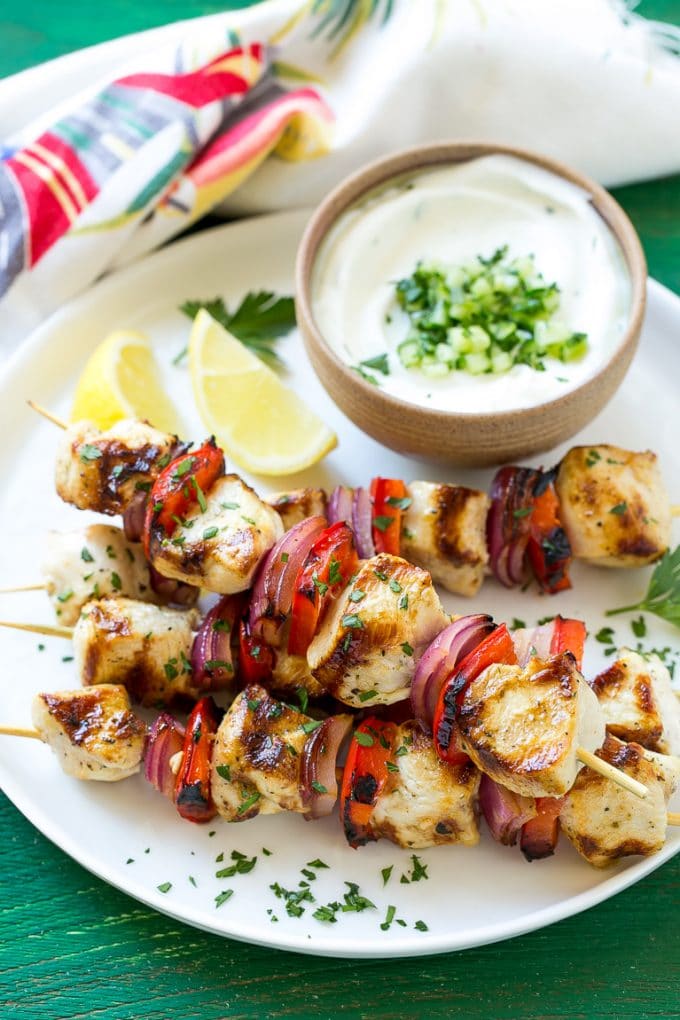 Greek chicken kabobs with vegetables, served with yogurt sauce.