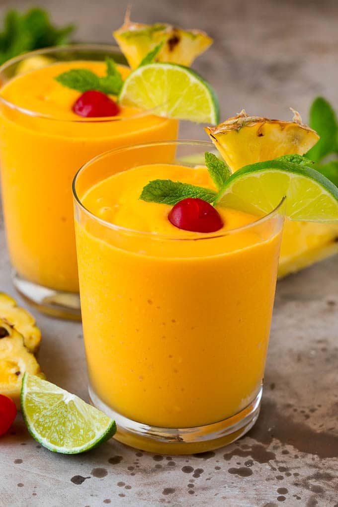 Tropical Smoothie Recipe | Mango Smoothie | Pineapple Smoothie #smoothie #mango #pineapple #banana #drink #uzhal Two tropical smoothies with fresh mint, lime wedges and sliced pineapple.