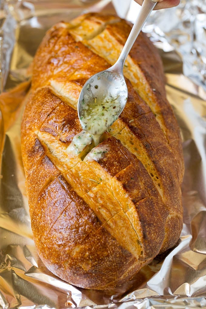 Pull Apart Bread | Garlic Bread | Cheese Bread #bread #garlic #cheese #sidedish #appetizer #uzhal A spoon drizzling garlic butter over a loaf of bread.