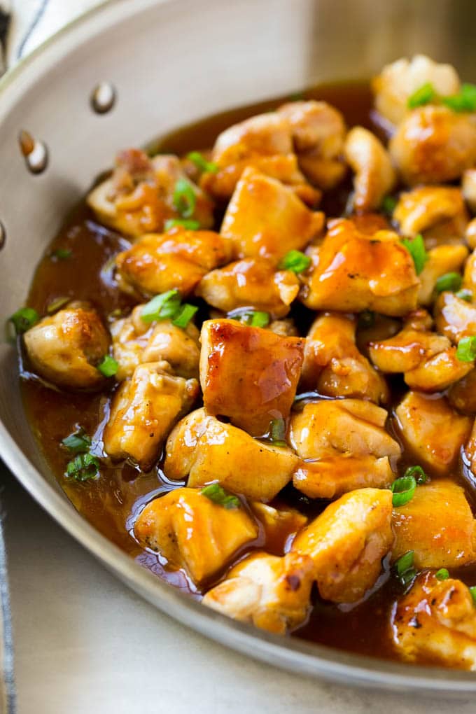 Bourbon Chicken | Sauteed Chicken | Chicken Stir Fry | Easy Chicken Recipe #chicken #dinner #uzhal Bourbon chicken in a skillet coated in sauce and topped with green onions.