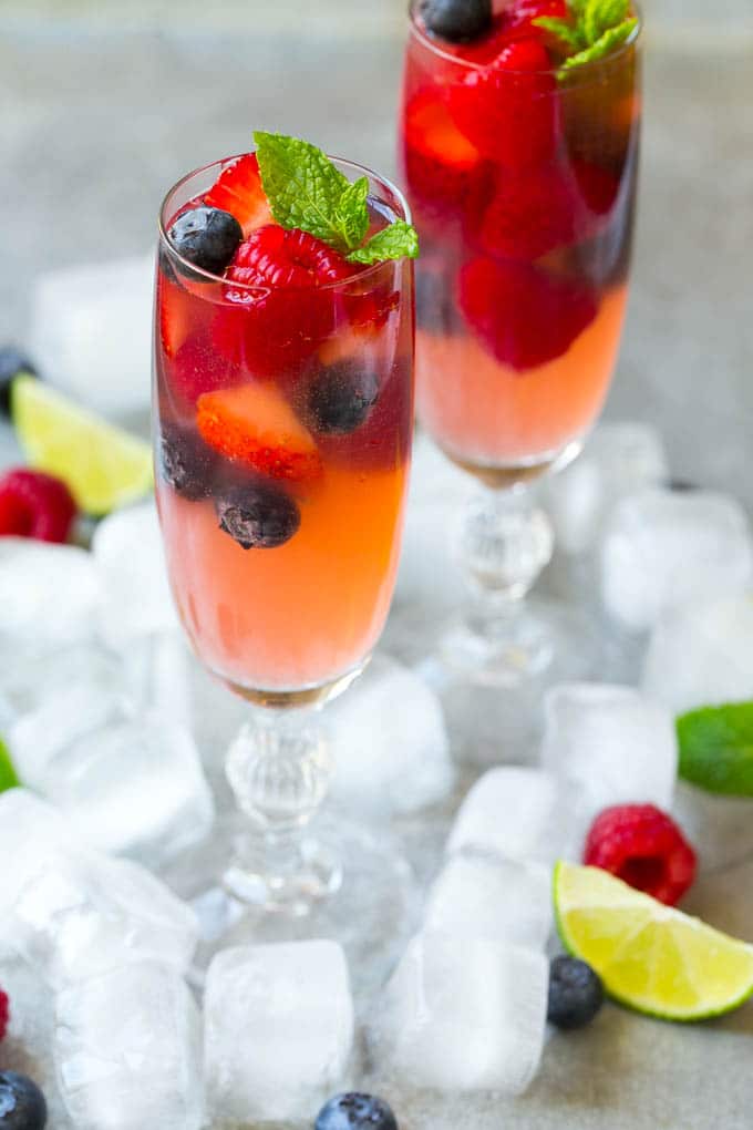 Berry Champagne Punch Recipe | Champagne Cocktail | Lime Cocktail | Berry Punch | Champagne Recipe #champagne #punch #berries #drink #uzhal Two champagne flutes filled with berry champagne punch garnished with berries.