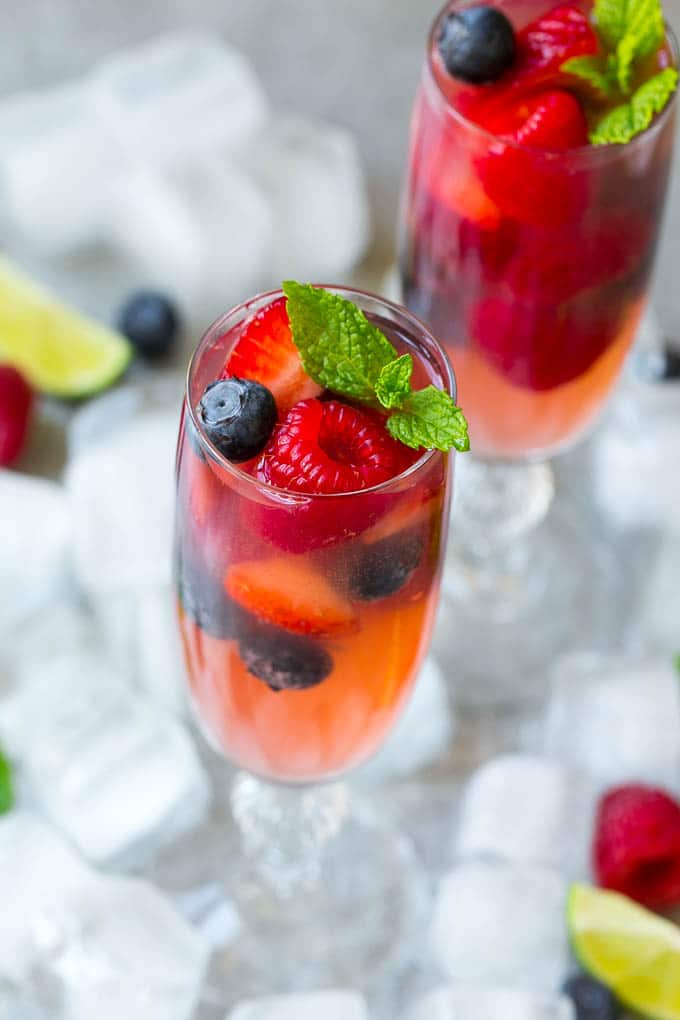 Berry Champagne Punch Recipe | Champagne Cocktail | Lime Cocktail | Berry Punch | Champagne Recipe #champagne #punch #berries #drink #uzhal Two glasses of refreshing champagne punch with berries and mint on top.