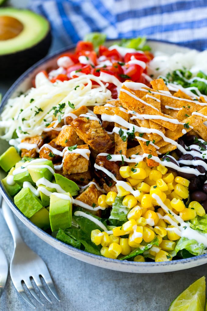 BBQ Chicken Salad Recipe | Chopped BBQ Chicken Salad | CPK Copycat Recipe | California Pizza Kitchen Copycat Recipe | Chicken Ranch Salad #copycat #CPK #BBQchicken #chicken #salad #dinner #uzhal A bowl of BBQ chicken salad topped with a drizzle of ranch dressing.