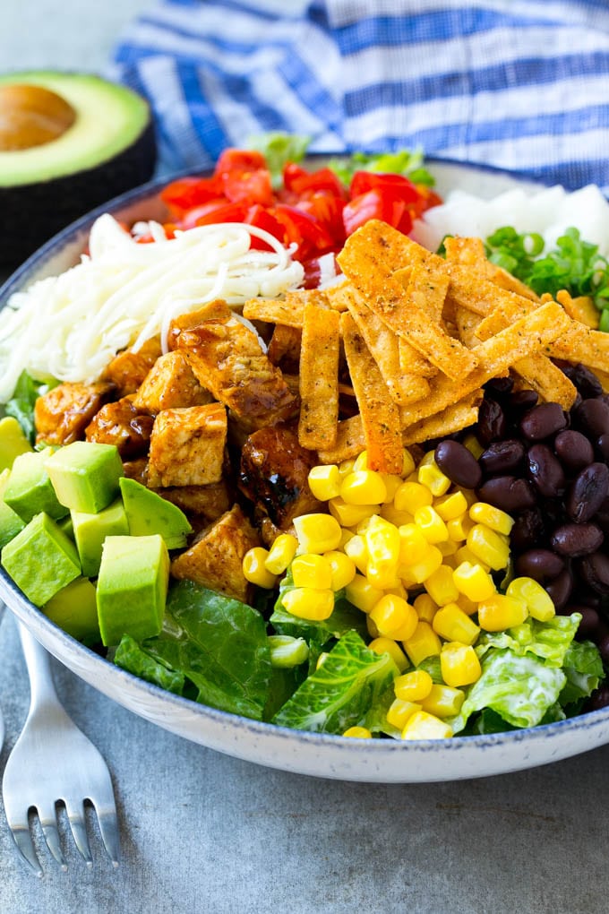 BBQ Chicken Salad Recipe | Chopped BBQ Chicken Salad | CPK Copycat Recipe | California Pizza Kitchen Copycat Recipe | Chicken Ranch Salad #copycat #CPK #BBQchicken #chicken #salad #dinner #uzhal A bowl of salad topped with chicken, tortilla strips, black beans, jiacama, avocado and tomatoes.