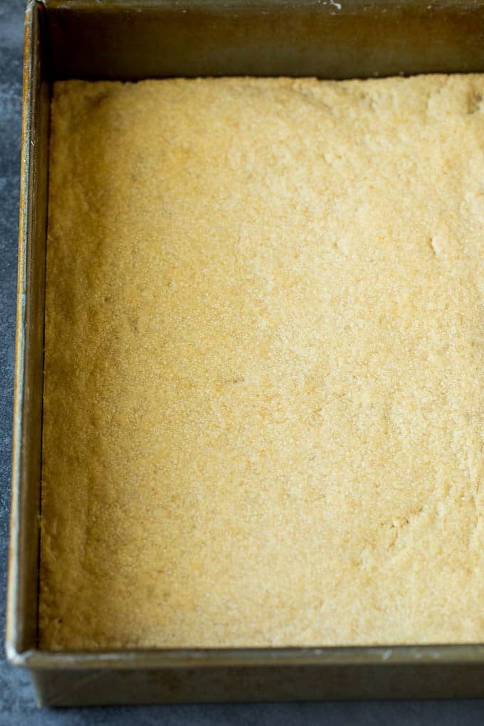 Pecan Pie Bars Recipe #pecans #pie #fall #pecanpie #dessert #thanksgiving #uzhal A shortbread crust in a baking pan.