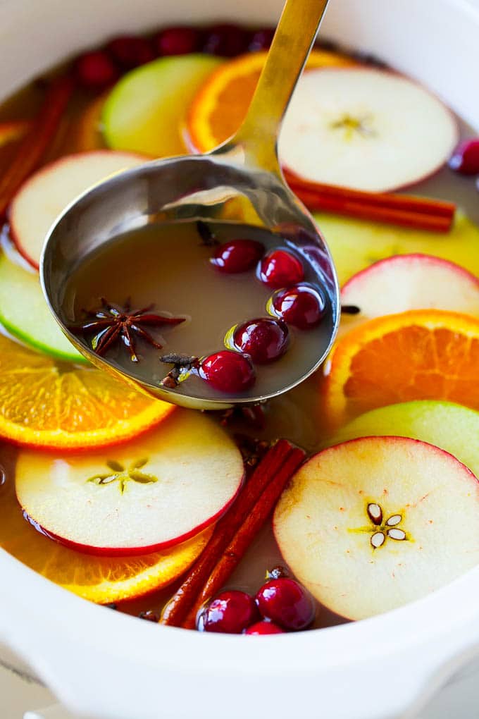 Slow Cooker Apple Cider | Mulled Apple Cider | Crockpot Apple Cider #cider #apple #applecider #drink #crockpot #slowcooker #uzhal A ladle scooping out some warm mulled drink.