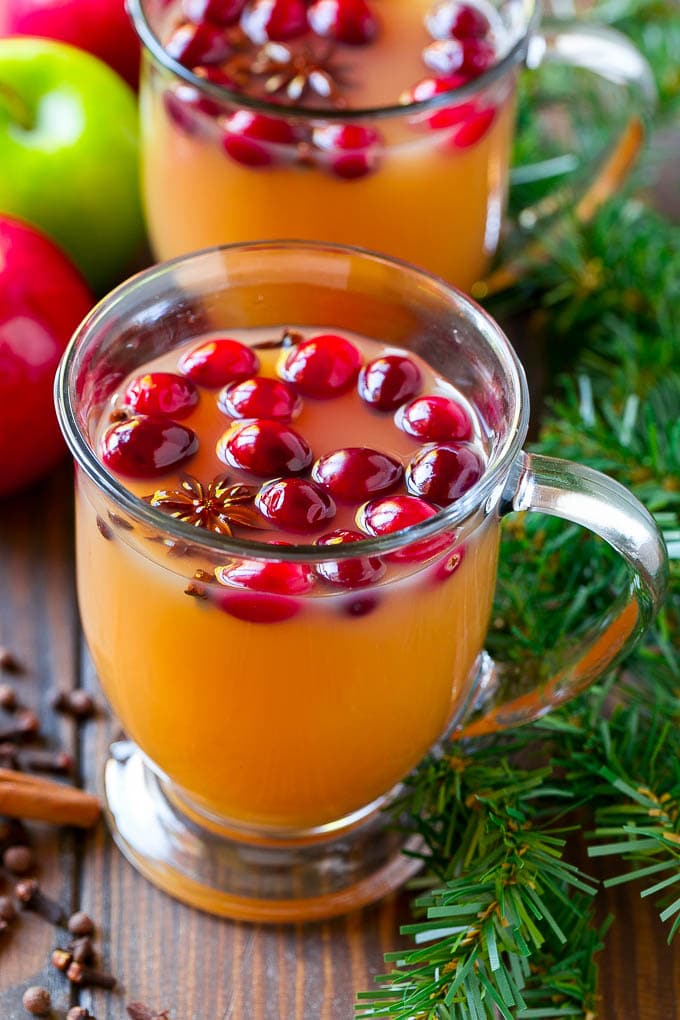 Slow Cooker Apple Cider | Mulled Apple Cider | Crockpot Apple Cider #cider #apple #applecider #drink #crockpot #slowcooker #uzhal Mugs of slow cooker apple cider garnished with cranberries.