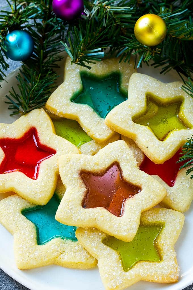 Stained Glass Cookies | Stained Glass Window Cookies | Christmas Cookies | Sugar Cookies | Holiday Cookies #cookies #stainedglasscookies #sugarcookies #christmascookies #christmas #holiday #dessert #uzhal A plate of star shaped stained glass cookies with colorful centers.