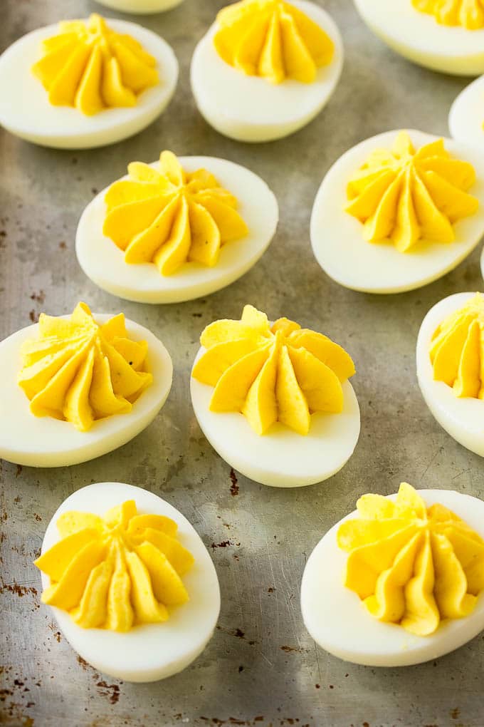 Bacon Deviled Eggs | Deviled Eggs Recipe #eggs #keto #lowcarb #bacon #appetizer #uzhal Deviled eggs with a decoratively piped filling on a sheet pan.