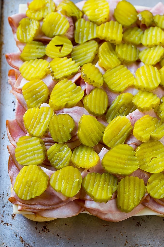 Cuban Sliders Recipe | Cuban Sandwich Recipe | Slider Sandwiches | Ham and Cheese Sliders #sliders #sandwiches #ham #cheese #appetizer #uzhal Bread layered with cheese, ham and pickles.
