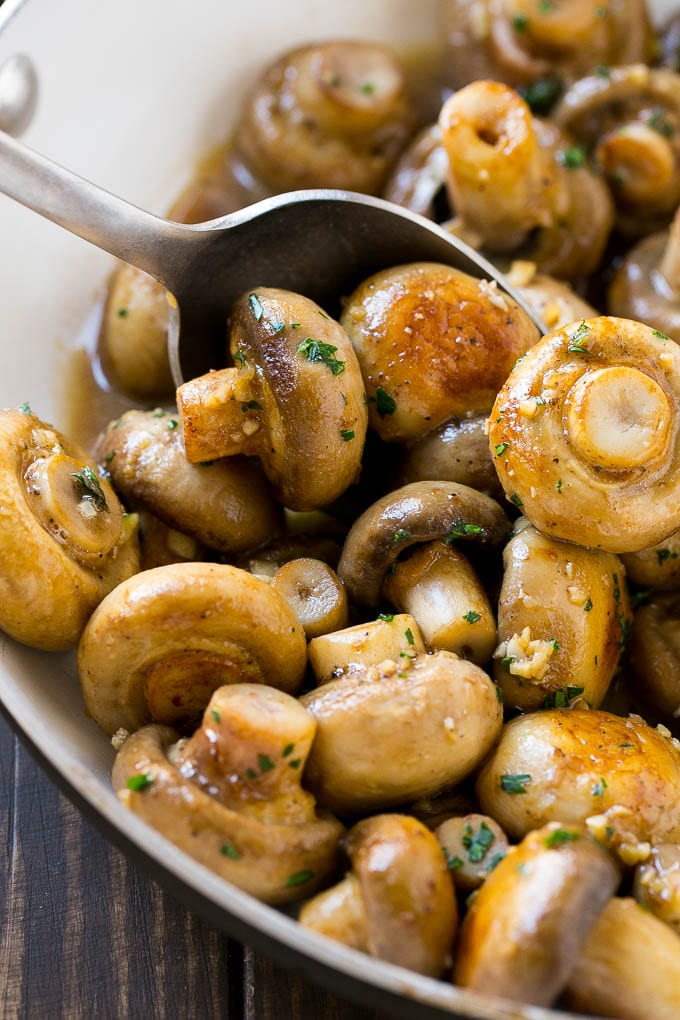 Garlic Mushrooms Recipe | Steakhouse Mushrooms | Sauteed Mushrooms | Garlic Butter Mushrooms | Mushroom Side Dish #mushrooms #butter #keto #lowcarb #dinner #sidedish #uzhal A pan of sauteed garlic mushrooms with a serving spoon.