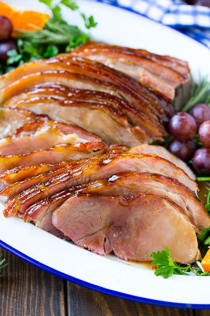 Coca Cola Ham | Coke Glazed Ham | Easter Ham | Christmas Ham | Holiday Ham Recipe #ham #easter #christmas #dinner #uzhal A platter of sliced coca cola ham with herbs.