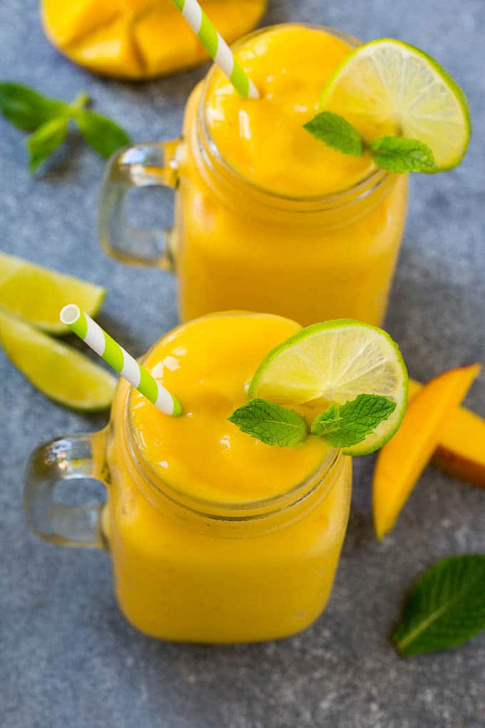 Mango Smoothie Recipe | Mango Recipe | Healthy Smoothie #mango #smoothie #drink #uzhal Two jars full of mango smoothie, garnished with lime slices and fresh mint.