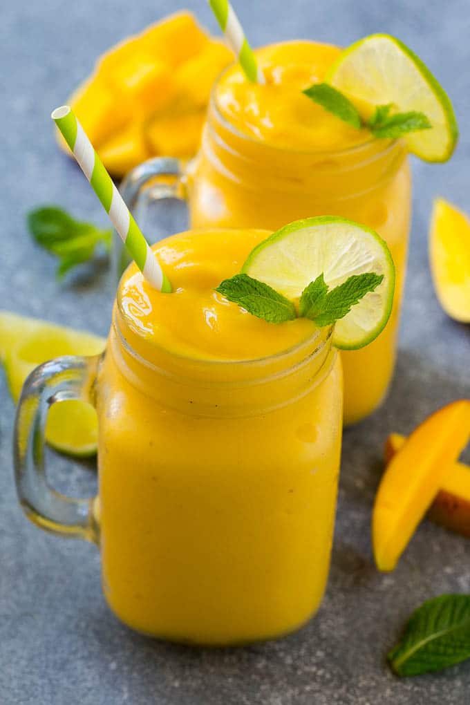 Mango Smoothie Recipe | Mango Recipe | Healthy Smoothie #mango #smoothie #drink #uzhal Mango smoothie in a mug topped with a slice of lime and mint sprig.