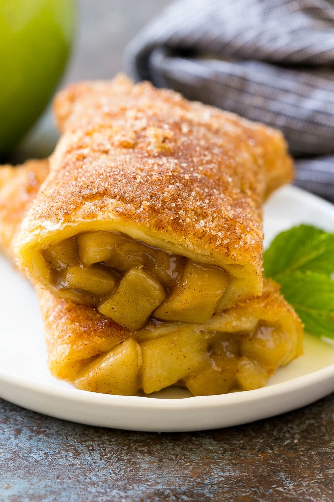 Fried Apple Pies Recipe | McDonald's Copycat Recipe | Apple Pie | Apple Hand Pies #pie #apples #applepie #dessert #snack #uzhal A cross section of a fried apple pie on a plate.