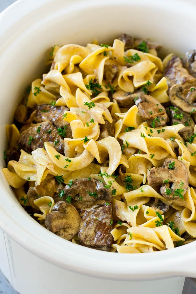 Slow Cooker Beef Stroganoff Recipe | Crock Pot Beef Stroganoff | Beef Recipe #slowcooker #crockpot #beef #mushrooms #pasta #dinner #uzhal Slow cooker beef stroganoff with chunks of beef, mushrooms and egg noodles topped with parsley.
