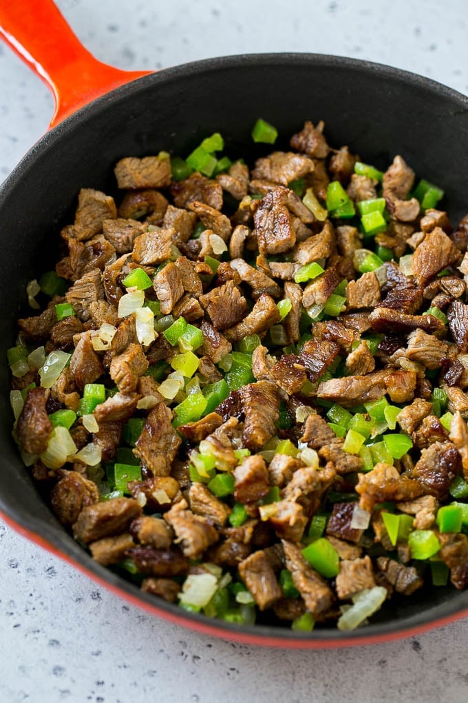 Philly Cheesesteak Dip Recipe | Cheesy Dip | Baked Cheese Dip #steak #dip #appetizer #cheese #uzhal Seared rib eye steak, peppers and onions in a pan.