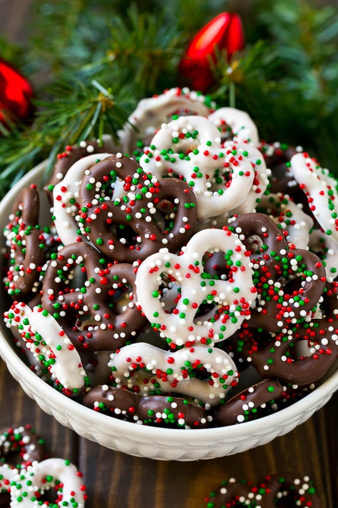 Chocolate Covered Pretzels Recipe | Sprinkle Pretzels | No Bake Dessert #pretzels #chocolate #christmas #sprinkles #candy #uzhal Chocolate covered pretzels in a bowl with Christmas sprinkles.