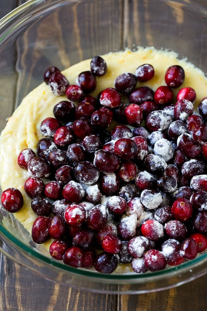 Cranberry Bread Recipe | Cranberry Loaf | Cranberry Orange Bread #cranberry #bread #baking #dessert #fall #uzhal Orange batter topped with a pile of fresh cranberries in a mixing bowl.