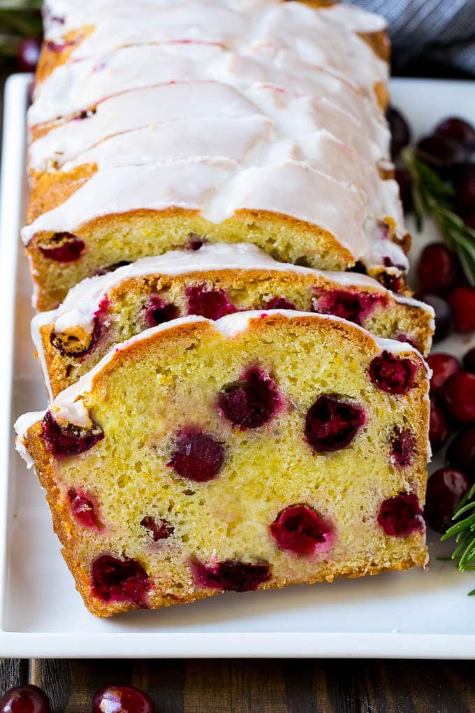 Cranberry Bread Recipe | Cranberry Loaf | Cranberry Orange Bread #cranberry #bread #baking #dessert #fall #uzhal Slices of cranberry bread topped with orange glaze.