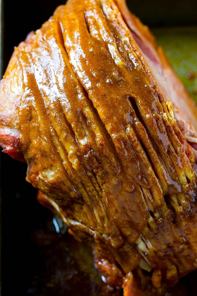 Honey Baked Ham Recipe | Glazed Ham | Holiday Ham #ham #dinner #uzhal #christmas #thanksgiving #easter A ham coated in sugar glaze in a baking pan.