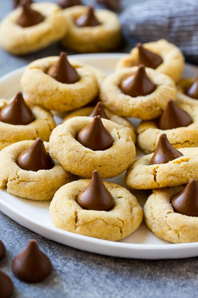 Peanut Butter Blossoms Recipe | Hershey Kiss Cookies | Chocolate Peanut Butter Cookies #cookies #peanutbutter #chocolate #dessert #baking #christmas #christmascookies #uzhal A serving plate of peanut butter blossoms.