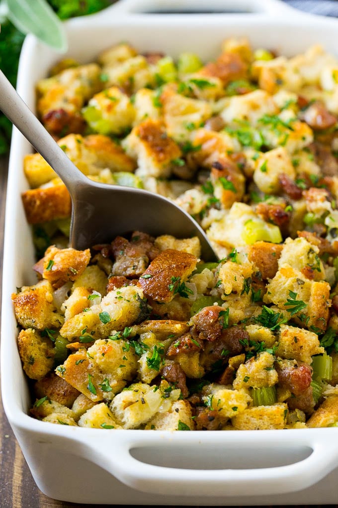 Sausage Stuffing Recipe | Thanksgiving Stuffing | Make Ahead Stuffing #stuffing #thanksgiving #sausage #sidedish #dinner #uzhal A baking dish of sausage stuffing with a serving spoon in it.