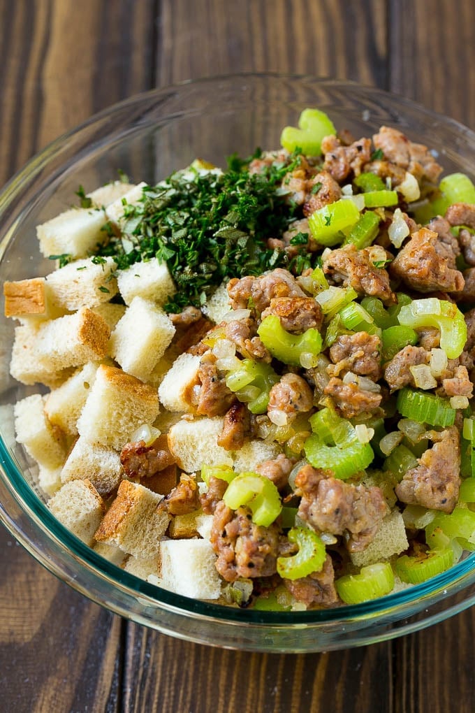 Sausage Stuffing Recipe | Thanksgiving Stuffing | Make Ahead Stuffing #stuffing #thanksgiving #sausage #sidedish #dinner #uzhal Meat, sauteed vegetables and bread cubes in a mixing bowl.