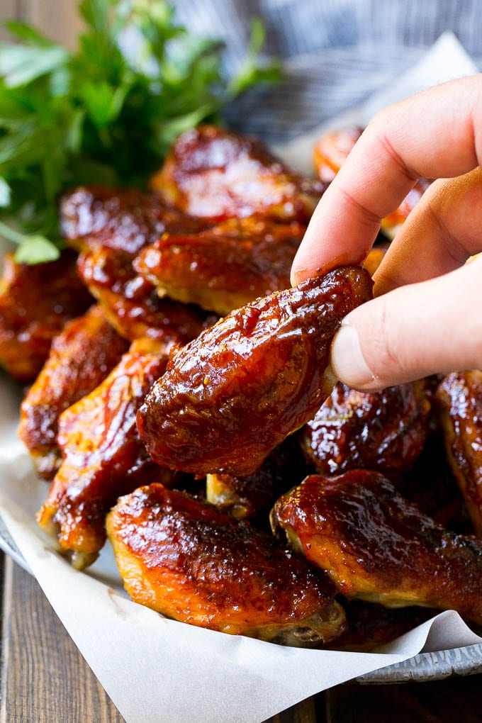 Smoked Chicken Wings | Barbecue Chicken Wings | BBQ Chicken Wings #chicken #wings #bbq #barbecue #appetizer #dinner #uzhal A pile of smoked chicken wings with a hand reaching out for one.
