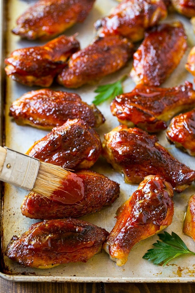 Smoked Chicken Wings | Barbecue Chicken Wings | BBQ Chicken Wings #chicken #wings #bbq #barbecue #appetizer #dinner #uzhal BBQ sauce brushed onto a sheet pan of smoked chicken wings.