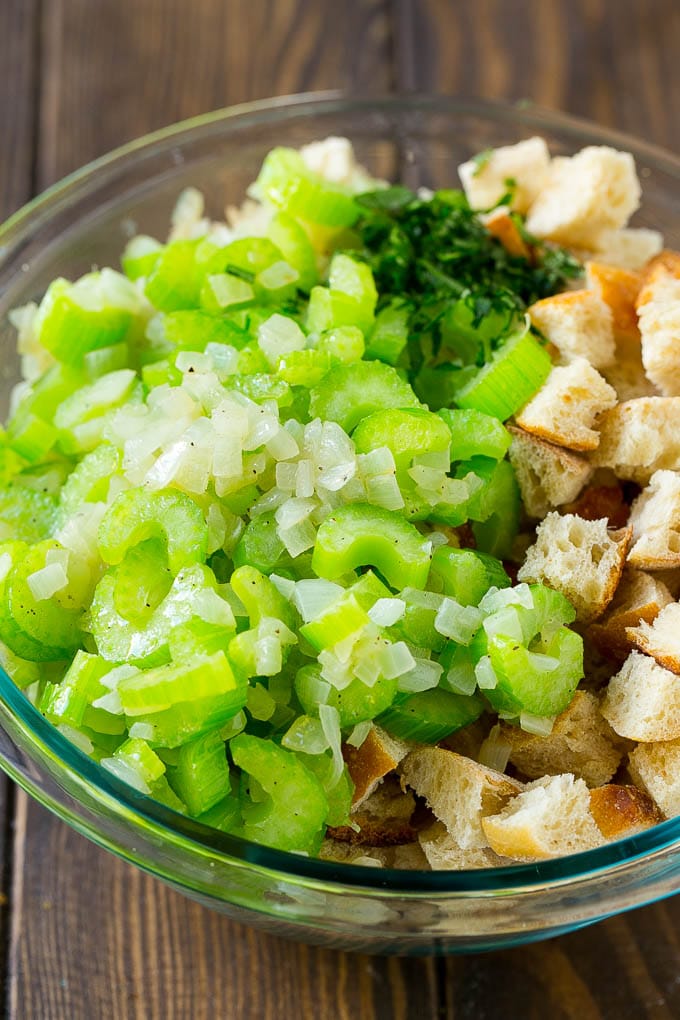 Turkey Stuffing Recipe | Thanksgiving Stuffing | Classic Stuffing #thanksgiving #stuffing #sidedish #fall #uzhal Bread cubes, celery, onion and herbs in a mixing bowl.