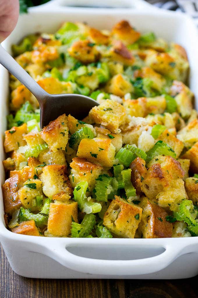 Turkey Stuffing Recipe | Thanksgiving Stuffing | Classic Stuffing #thanksgiving #stuffing #sidedish #fall #uzhal Turkey stuffing in a casserole dish with a serving spoon in it.
