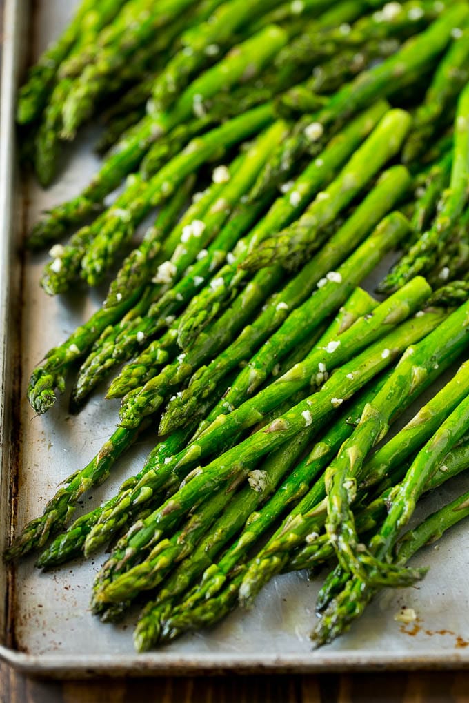 Roasted Asparagus Recipe | Baked Asparagus | Asparagus Side Dish #asparagus #garlic #sidedish #keto #lowcarb #dinner #uzhal Roasted stalks with garlic and olive oil on a baking sheet.