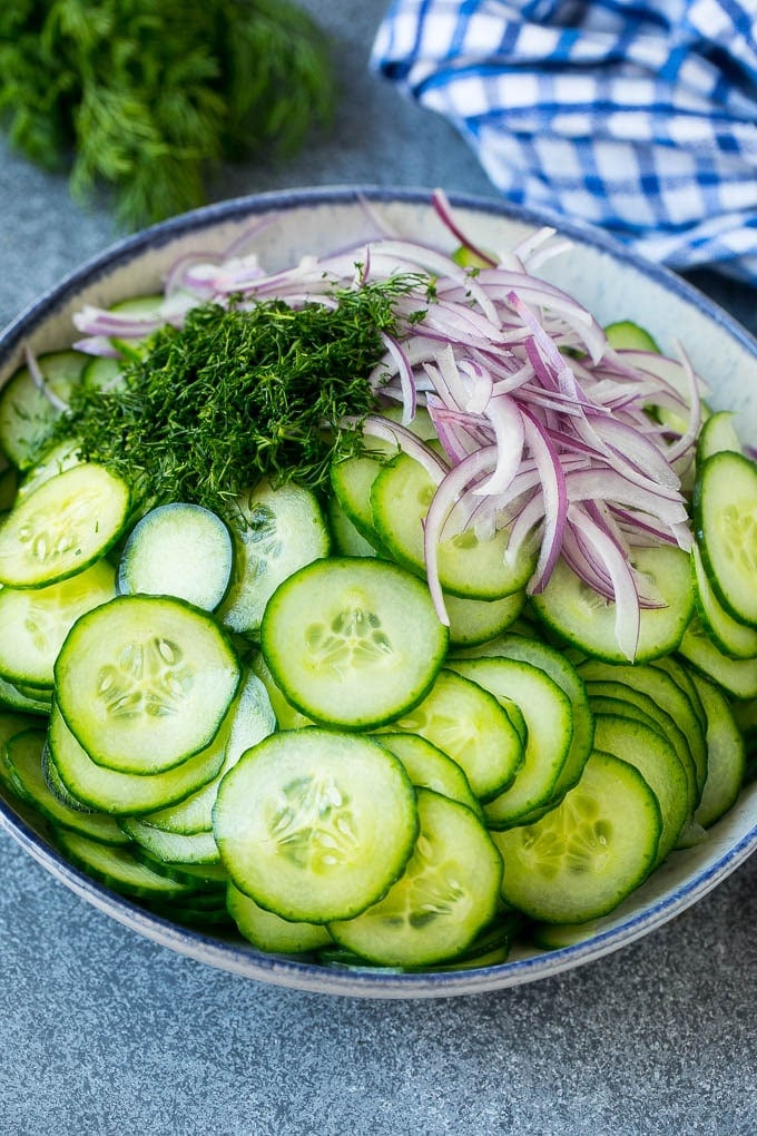 Creamy Cucumber Salad Recipe | German Cucumber Salad | Cucumber Salad #cucumber #salad #dinner #lunch #uzhal #cucumbersalad Thinly sliced cucumbers, red onion and fresh dill in a mixing bowl.