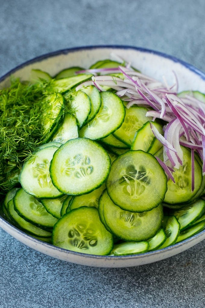 Ingredients including red onion and dill in a bowl.