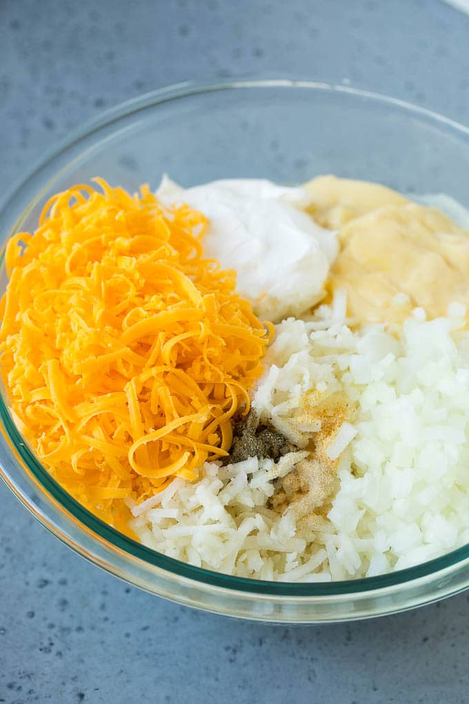 Hash Brown Casserole | Potato Casserole | Hash Brown Side Dish #potatoes #cheese #casserole #sidedish #uzhal A bowl of potato shreds, cheese, cream of chicken soup, sour cream and seasonings.