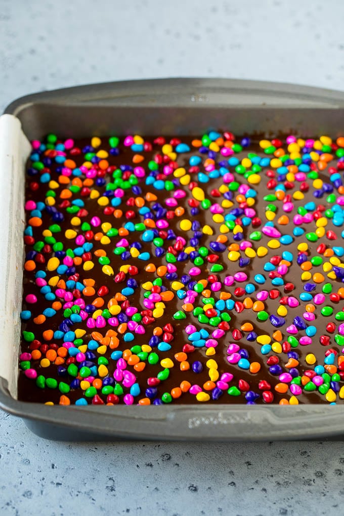 Cosmic Brownies Recipe | Cocoa Brownies | Frosted Brownies #brownies #chocolate #dessert #uzhal #sprinkles A pan of cosmic brownies with rainbow sprinkles on top.