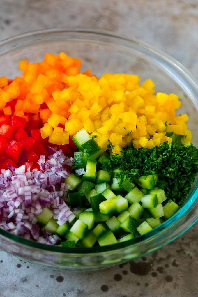 Israeli Salad Recipe | Cucumber Salad | Tomato Salad | Chopped Salad #salad #cleaneating #healthy #glutenfree #lowcarb #keto #sidedish #lunch #uzhal Chopped peppers, cucumbers, tomatoes and onions in a bowl.