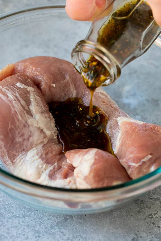 Marinated Pork Tenderloin Recipe | Pork Tenderloin Marinade | Pork Marinade #pork #porktenderloin #marinade #dinner #grilling #uzhal Marinade being poured over pork tenderloin.