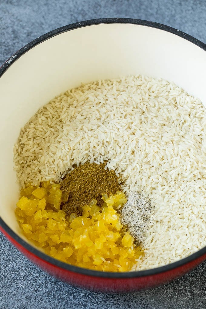 Black Beans and Rice Recipe | Cuban Black Beans | Beans and Rice #beans #rice #blackbeans #sidedish #glutenfree #dinner #uzhal Onions, garlic, white rice and spices in a pot.