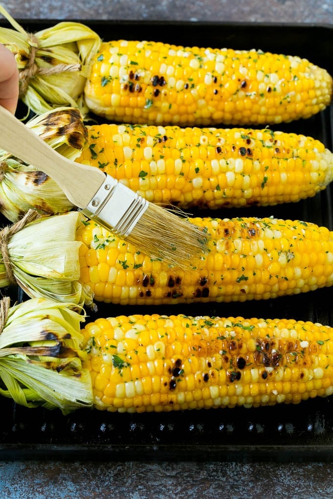 Grilled Corn on the Cob Recipe | Corn Recipe #corn #grilling #summer #sidedish #dinner #uzhal Cobs being brushed with herb butter.